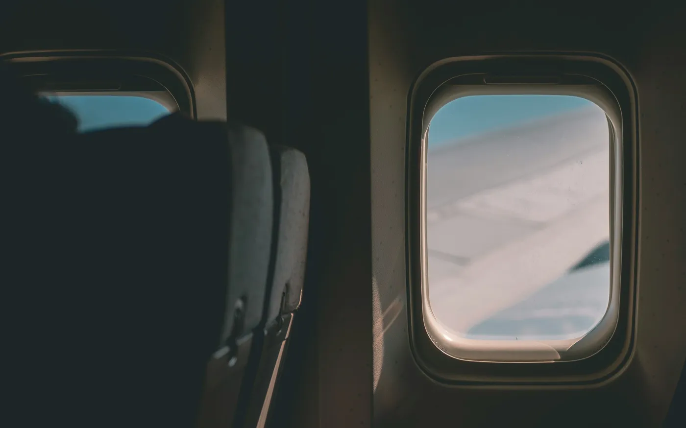 a view of the wing of an airplane through a window by Ryu Kim courtesy of Unsplash.