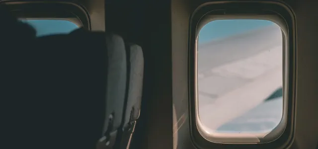 a view of the wing of an airplane through a window by Ryu Kim courtesy of Unsplash.