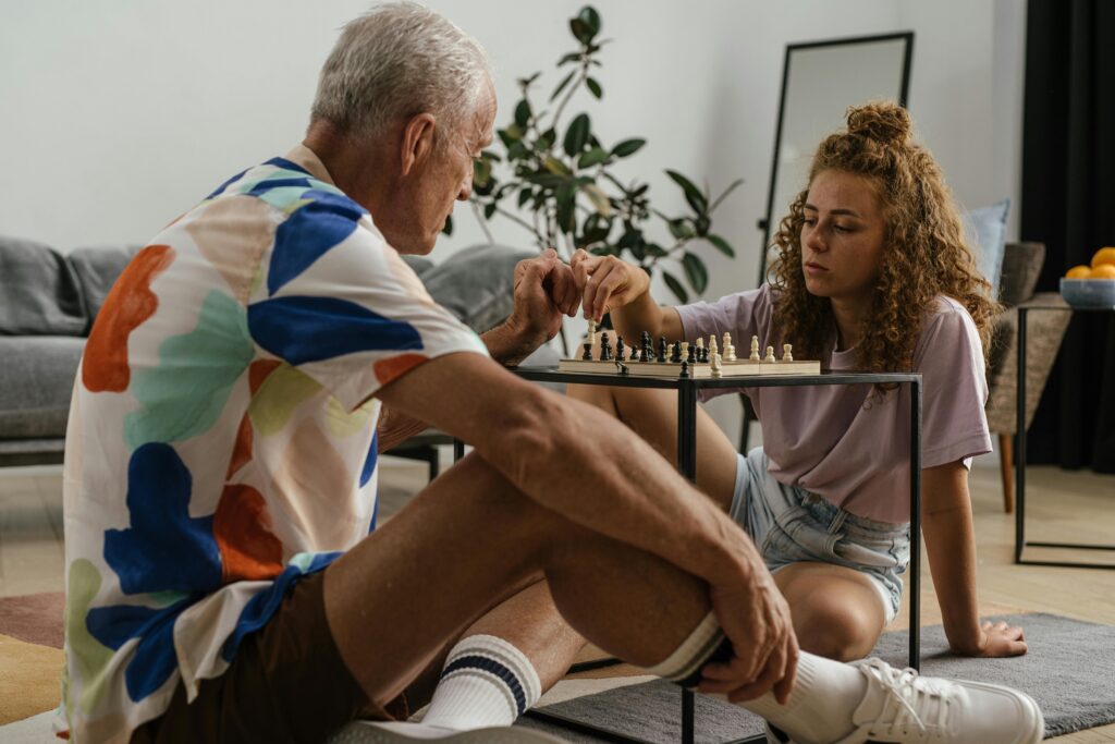 pexels-photo-8900002-8900002 A grandfather and granddaughter spend quality time playing chess indoors, fostering family bonding.